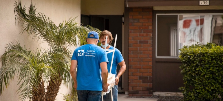 Local movers Houston carrying chairs into a house