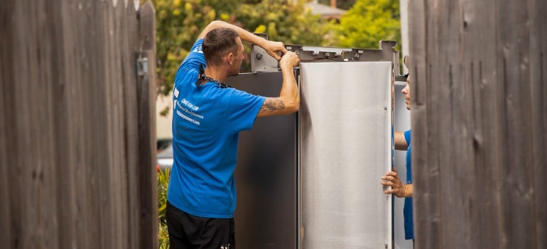 Movers packing up a refrigerator